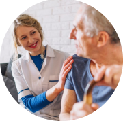 Smiling female caregiver offering support to elderly man holding a walking stick